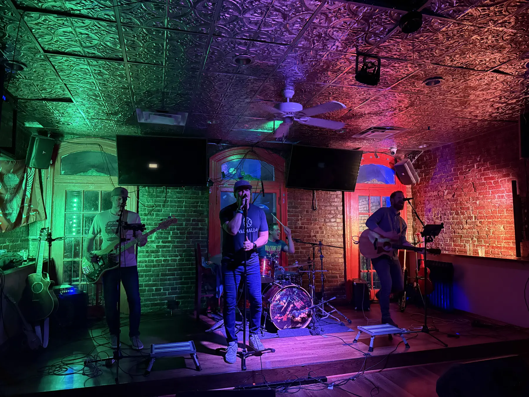 The band performing against a stone wall